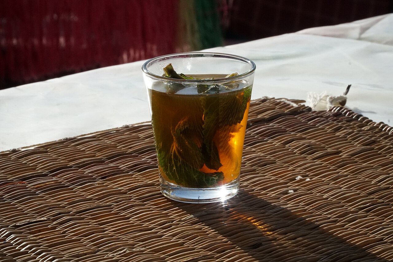 Moroccan mint tea being poured into a traditional glass in Marrakesh